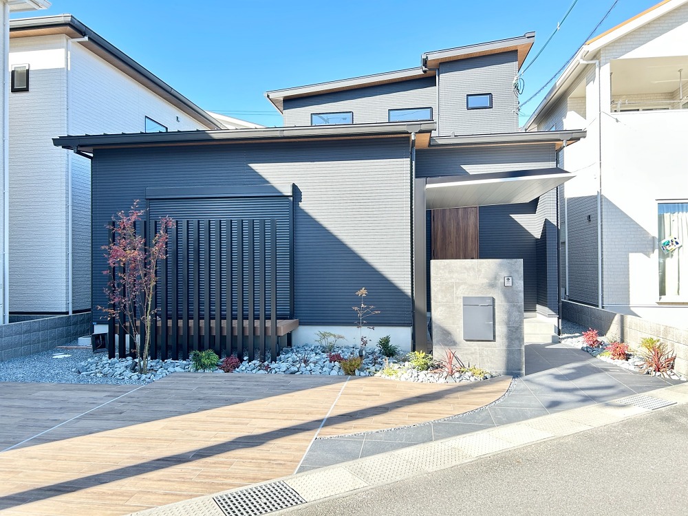 【姫路市　H様邸】【after】駐車スペースに木目調タイルを使うことで、インパクトのあるエントランスが実現しました。また、木目調タイルはナチュラルな風合いがあり、曲線を取り入れたアプローチのデザインは、訪れる人に柔らかい雰囲気を演出してくれます。駐車場用タイルには、他にもさまざまな種類があります。タイヤ痕が残ることを心配して土間コンクリートを敬遠されている方は、是非、駐車場用タイルも検討していただきたいです。あなたのお家にも、ぜひこの新しいスタイルを取り入れてみてください。（使用商品）駐車場用タイル：アイコットリョーワ　木目調・グレー系